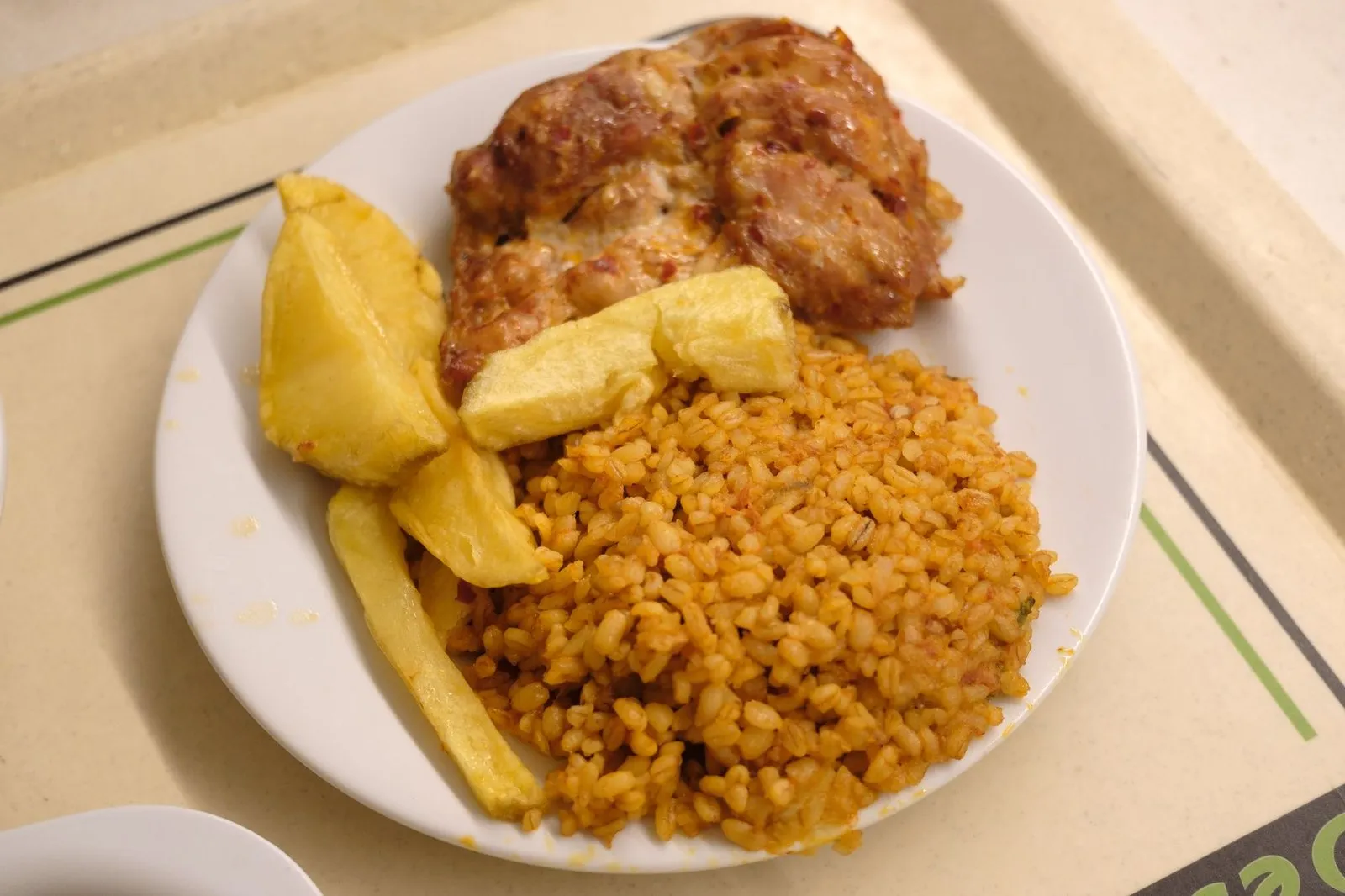 Plate of chicken, potato wedges and rice